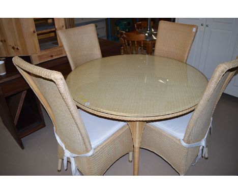 A modern Lloyd Loom style circular conservatory table; together with four matching high back chairs with loose seat cushions.