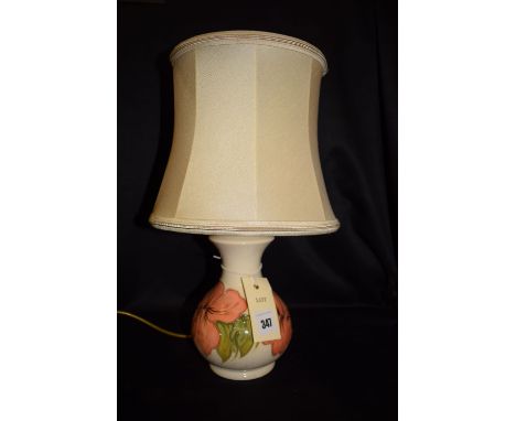 A modern Moorcroft popular vase-shaped table lamp with cream shade, decorated with raised flowers and leaves on cream ground.