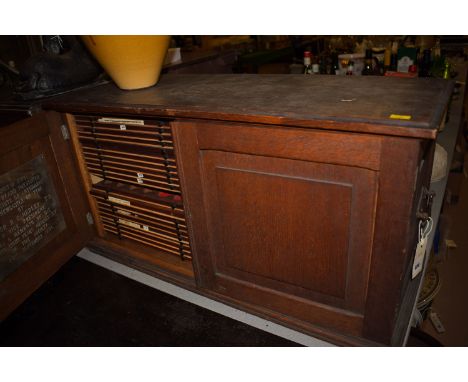 An oak table coin cabinet, fitted two panelled doors enclosing a fitted interior of drawers.