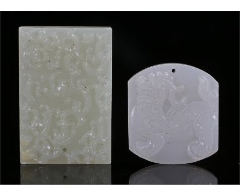 Two 19th Century Chinese jade pendants an example carved with a temple guardian lion the other a stylised dragon amongst clou
