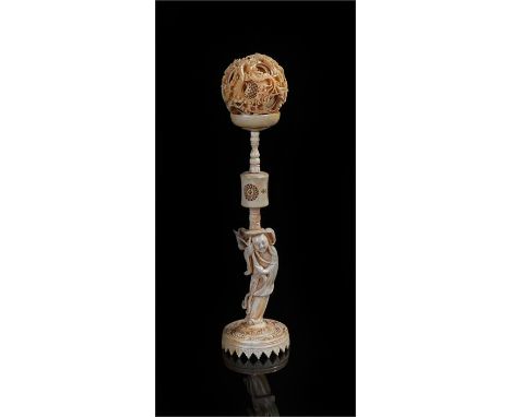 Chinese ivory puzzle ball and stand, the ball carved with flower heads and dragons, the stand with turned and pierced column 