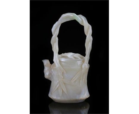 Chinese jade tea pot and cover, carved with a twisted bamboo handle above a leaf applied body, 19cm high