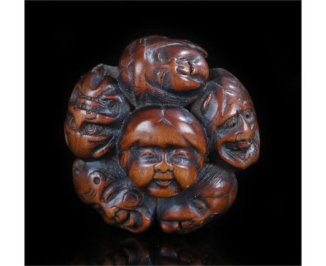 Meiji period carved wooden netsuke formed as a group of masks 40mm diameter