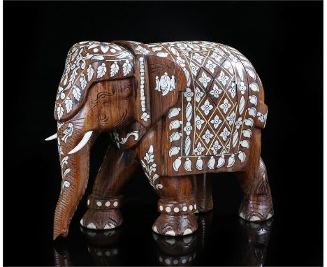 Early 20th century hardwood and ivory inlaid elephant, with all over stylised floral and leaf decoration, 20cm high, 25cm fro