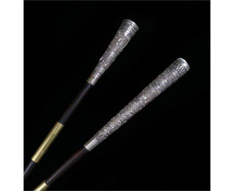 Two 19th Century Indian white metal swagger sticks, the first decorated with elephants, leopards and antelope among trees and