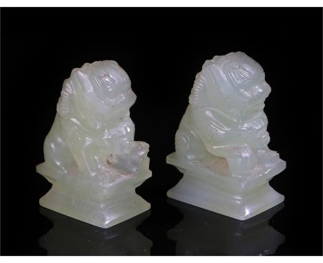 Pair of Jade dogs of Fo, each with a paw raised on a sphere, 5cm high, (2)
