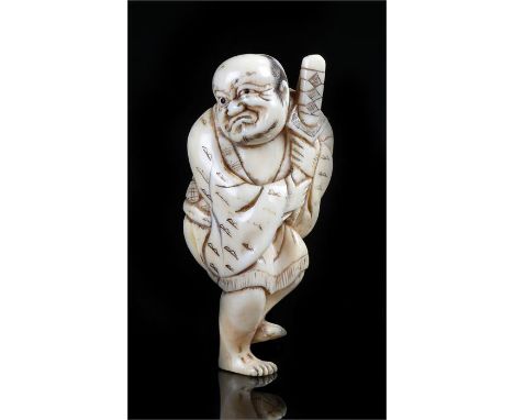19th Century Japanese ivory netsuke, carved as a figure laying down clutching a sword, 6.5cm long