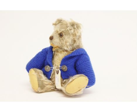 A 1950's Steiff Zotty bear, silver button in ear, loved condition with a few repairs, height 26cm, dressed in a blue cardigan