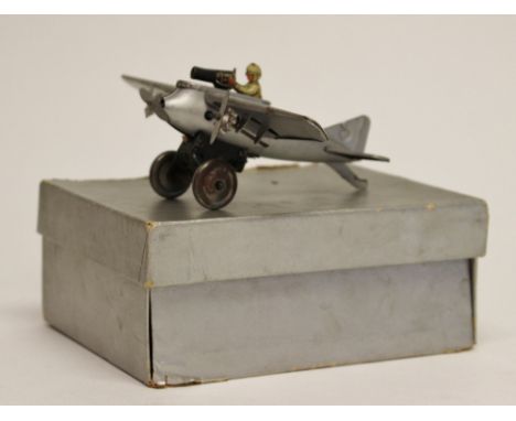 Geisha (Made in Germany) Tinplate Single Engine Monoplane Fighter in silver, together with pilot and machine gun. Clockwork a