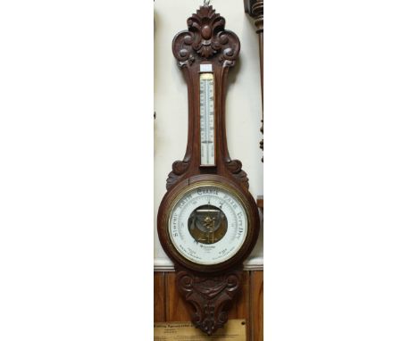 A late Victorian aneroid wheel barometer with thermometer by Dolland of London, No 6814, in carved oak case, 90cm
