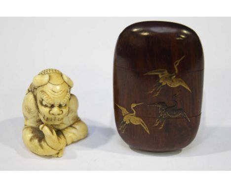 A Japanese Meiji period carved ivory netsuke modelled as seated figure with Fo Dog head, signed, 40mm high, together with a w