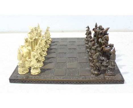 A modern composite chess set with board, the pieces modelled as wizards and dragons etc