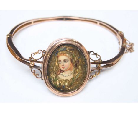 A 9ct gold stiff bangle with enamelled portrait of a girl (AF) Gross weight approximately 12.6g.