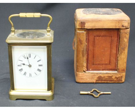 A late 19th / early 20th brass-cased carriage clock with eight-day movement striking a gong, enamel dial with Roman numerals,