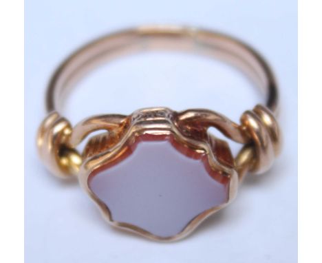 A yellow metal (tests as 14ct or more) signet ring, with double wire band and set with cartouche-shaped hardstone. Gross weig