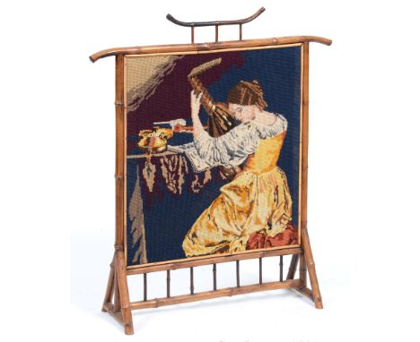 A Victorian bamboo firescreen, with woolwork banner of a musician, 88cm h A little dusty but in good condition
