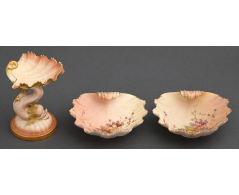 A Royal Worcester shell on dolphin pin tray and pair of shell shaped dishes, 1897 and circa, the dishes printed and painted w