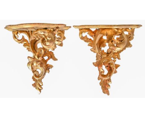 A pair of Florentine giltwood wall brackets, 20th c, the serpentine shelf on scrolling foliage, 28cm h Slightly dusty and wor