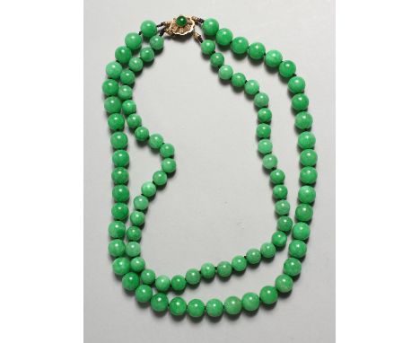 A GOOD TWO ROW JADE NECKLACE with gold clasp.