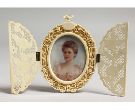 AN EDWARDIAN OVAL PORTRAIT MINIATURE OF A YOUNG LADY, bust length, housed in a pierced ivory strutt frame with bi-fold front.