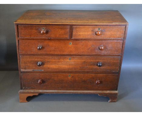 An 18th Century Oak Chest, the crossbanded top above two short and three long drawers with knob handles raised upon bracket f