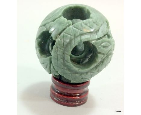 A Chinese jade carved concentric puzzle ball on stand