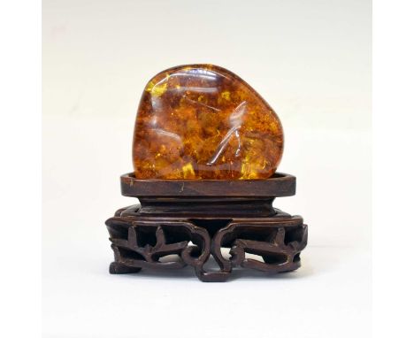 Boulder of Baltic amber, of D shape and good clarity, 7cm x 5.5cm x 2cm high, 55g approx, with an associated Chinese carved D