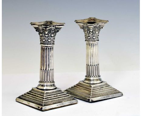 Pair of late Victorian silver candlesticks of Corinthian column form and standing on stepped square base, sponsor's mark of H
