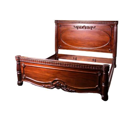 A reproduction Louis XVI style mahogany bedsteadThe headboard with foliate cornice above a fielded panel with carved cresting