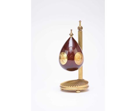 Theo Fabergé: The Sunburst Egg, 1995Mopane wood and gold plated metal, the polished wood egg inset with sunburst bosses, susp