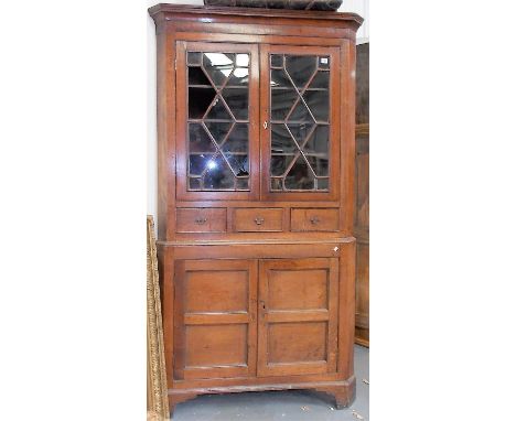 George III oak floor standing corner cupboard with a pair of astragal glazed doors over three short drawers and two cupboard 