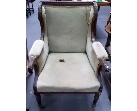 Edwardian walnut framed leaf carved and upholstered armchair with ring turned forelegs and ceramic castors.