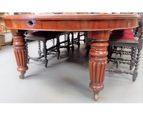 Large Victorian mahogany extending D-end dining table with three extra leaves and raised on ring turned and fluted legs with 