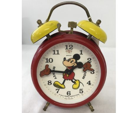 A classic Mickey Mouse alarm clock by Bradley. Twin yellow alarm bells to top. Moving arms and hands for hours and minutes.  