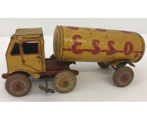 A tinplate wind-up Esso petrol tanker. Marked 'Made in England'. Yellow & red livery. In working order. 21cm long