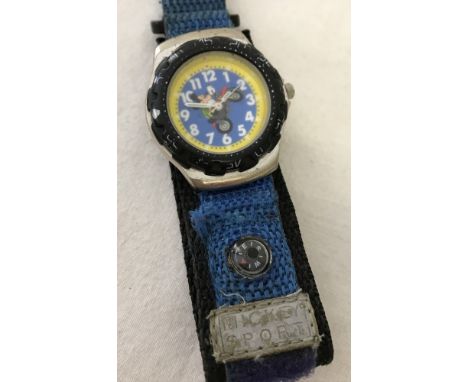 A Mickey Mouse wristwatch from the Sports range. Woven velcro strap with small compass. Face shows Mickey Mouse on a motorbik