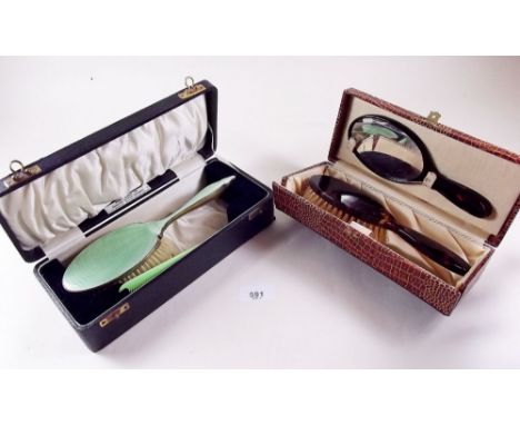 An enamel brush and a childs brush and mirror, both boxed