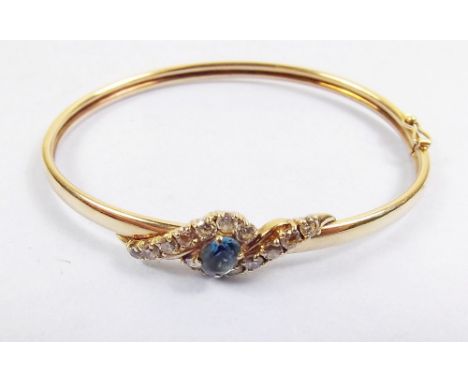 A 9 carat gold bangle set blue topaz and white paste