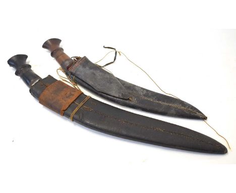 Two 19th century Indian / Nepalese kukris in leather scabbards, lacking skinning tools. Largest with ebony handle example mea