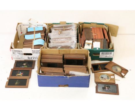 A large collection of wooden framed coloured magic lantern slides to include lever action examples, contained within four box