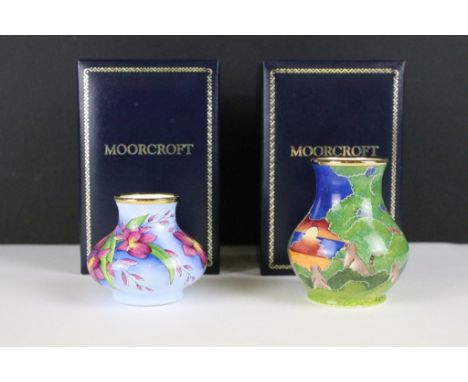 Two miniature Moorcroft vases with enamel decoration, both within fitted display boxes. 
