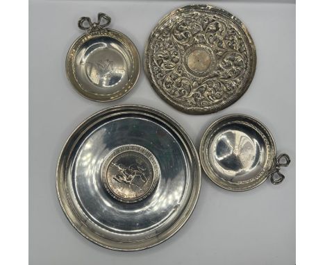 A selection of four white metal dishes -one incorporating an Elizabeth II five shilling piece, stamped 925; one fashioned fro