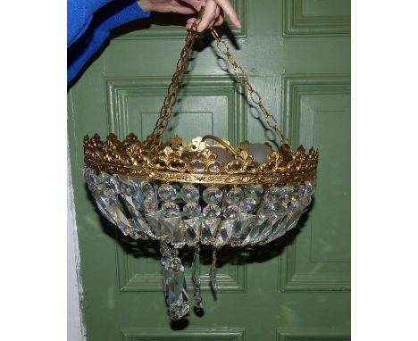 A 20th century pierced brass chandelier hung with prismatic drops