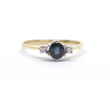 A sapphire and diamond ring, claw set oval cut sapphire and two small diamonds to the shoulders