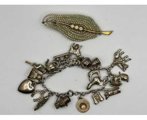 A white metal charm bracelet, with 19 charms on (one of which is stamped silver) (gross weight approx 58 grams) plus a pearl 