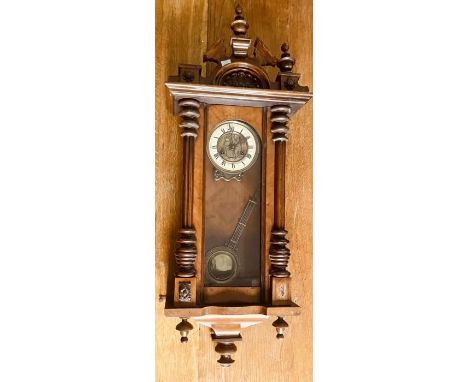 An early 20th century walnut Vienna wall clock, in a Gustav Becker style, turned finials on a broken pediment fitted on a mou