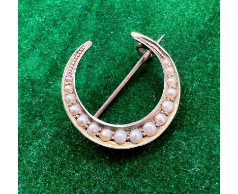 A Victorian seed pearl celestial brooch in the form of a crescent. Stamped 9ct and tests accordingly. Gross weight approx 3 g