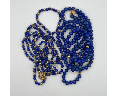 A 14 k gold clasp lapis lazuli and gilt metal bead necklace and another lapis lazuli necklace with gilt beads at intervals.