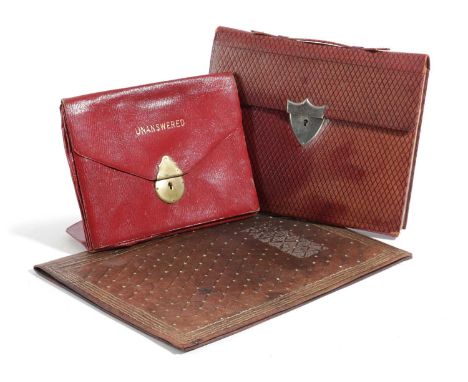 A RED LEATHER STATIONERY FOLDEREARLY 20TH CENTURYwith tooled lattice decoration and a shield-shaped clasp, the tan leather in