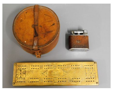A leather collar box, a 1920's brass cribbage board &amp; an oversized "The Cyclops" table lighter 